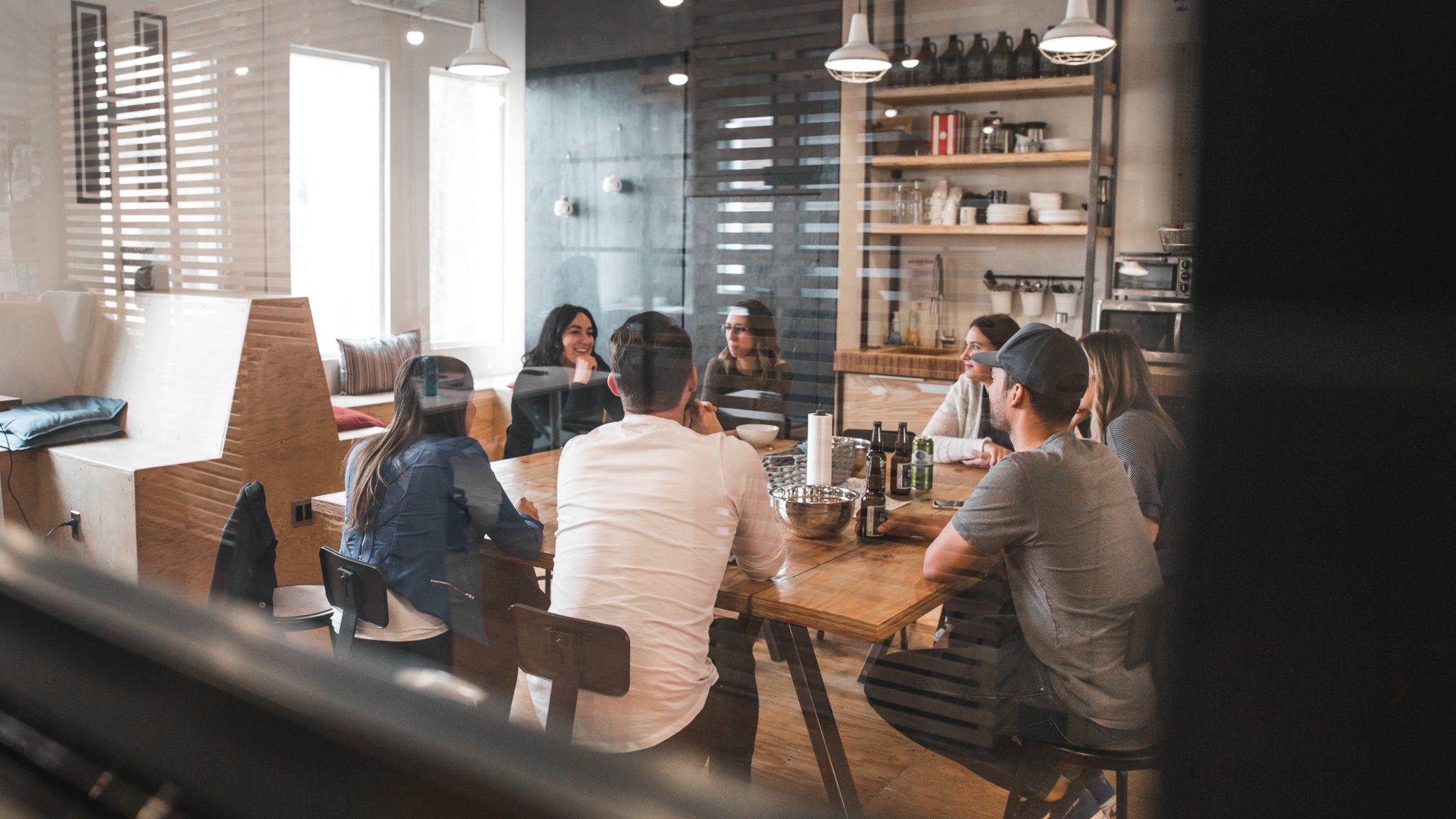 A group of people sit around a table in a meeting room